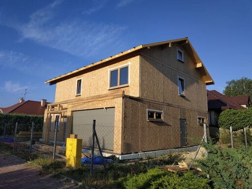 Casa de madera en construcción con cielo despejado.